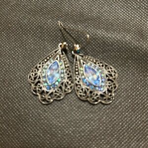 Beautiful high fashion earr with Blue sparkly center stone and side accents.
